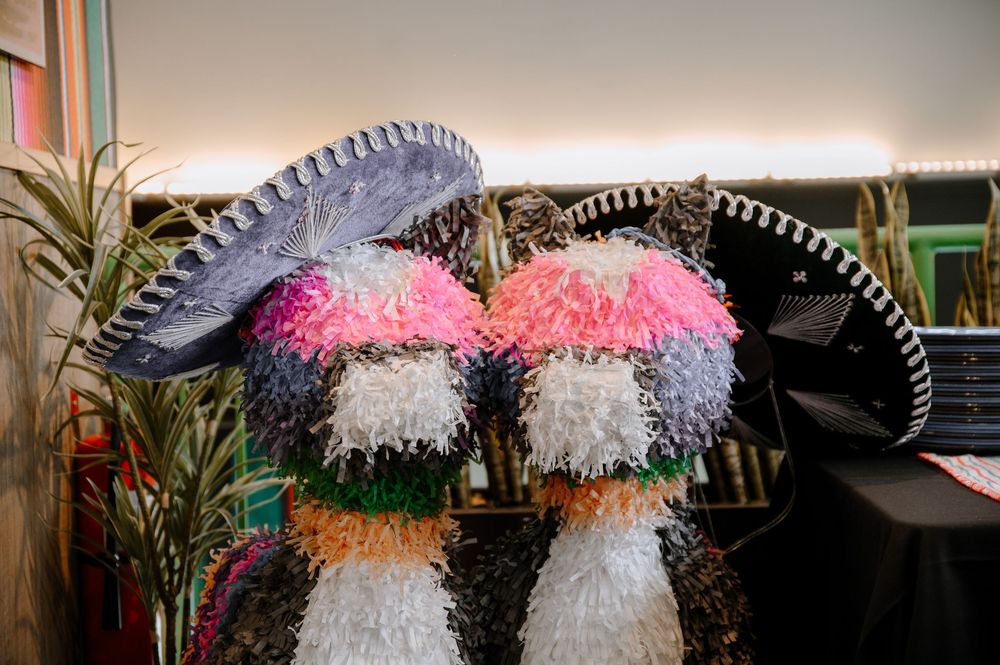 Colorful feathered carnival headdresses and costumes displayed in a row at a costume shop.