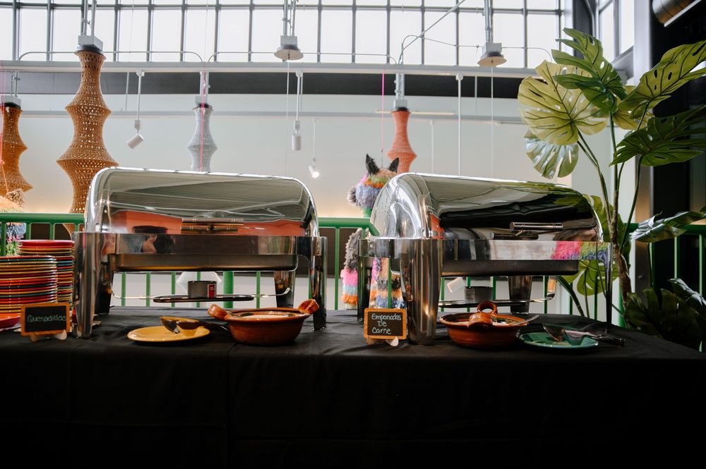 Modern restaurant interior with pendant lights and tropical plants creating a warm ambiance during sunset hours.