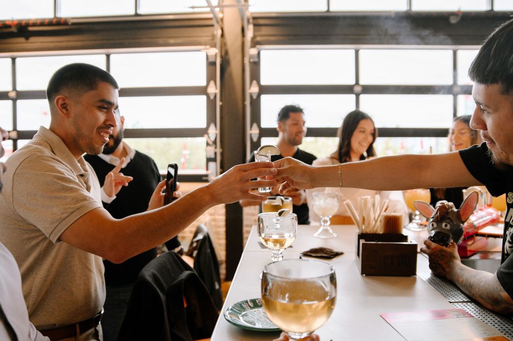 Friends gathered around a restaurant table sharing drinks and laughter during a casual dining experience.