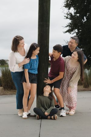 A playful group sits together on concrete steps sharing laughs and smiles.
