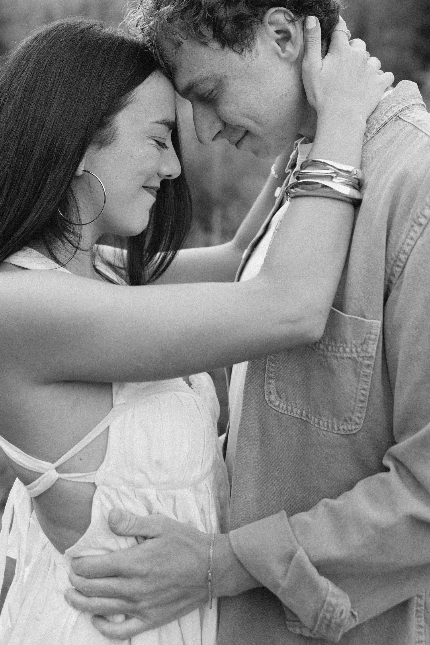 Two people embrace in white outfits while standing on red rock formations in a desert canyon landscape.