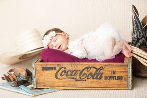 Vintage wooden Coca-Cola bottle crates stacked with antique style decor and white linens create a rustic display.