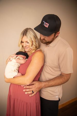 A couple in casual attire embraces tenderly in a series of intimate portrait photos against a warm beige background.
