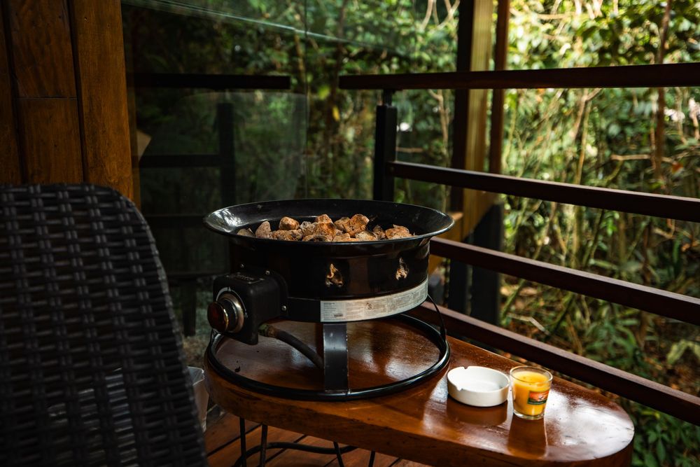 Rustic wooden interior with outdoor views through large windows and comfortable seating area.