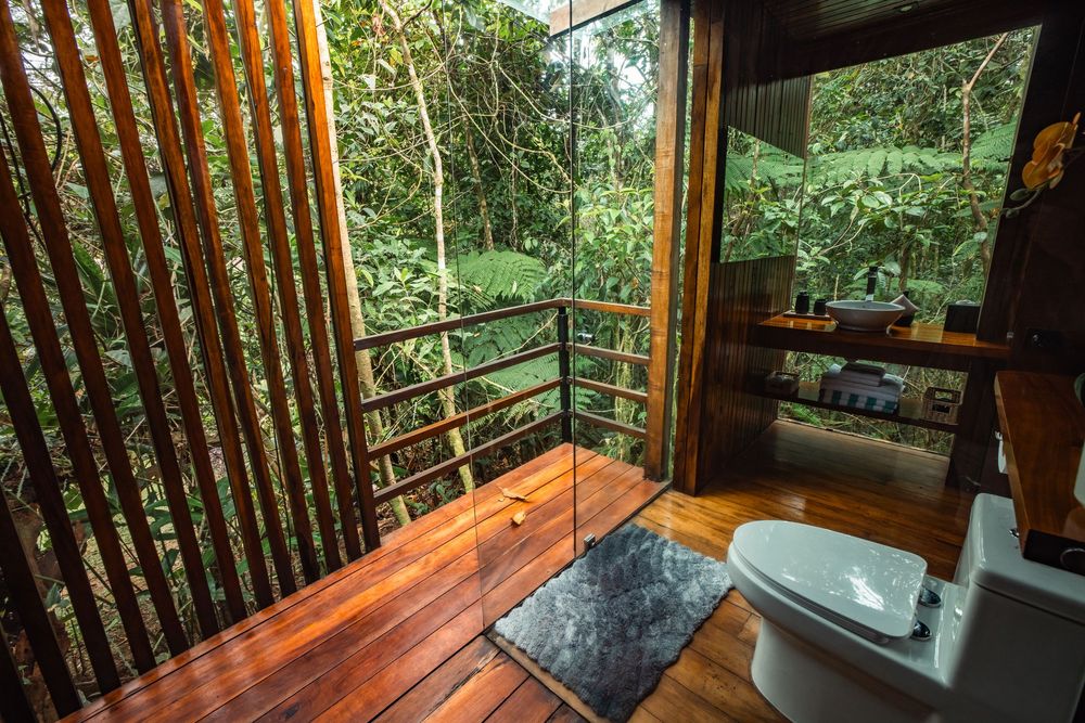 Panoramic forest views through large windows in a wooden cabin interior.