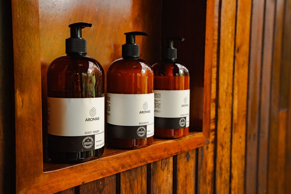 Row of amber glass bottles displayed on wooden shelf in cabin interior.