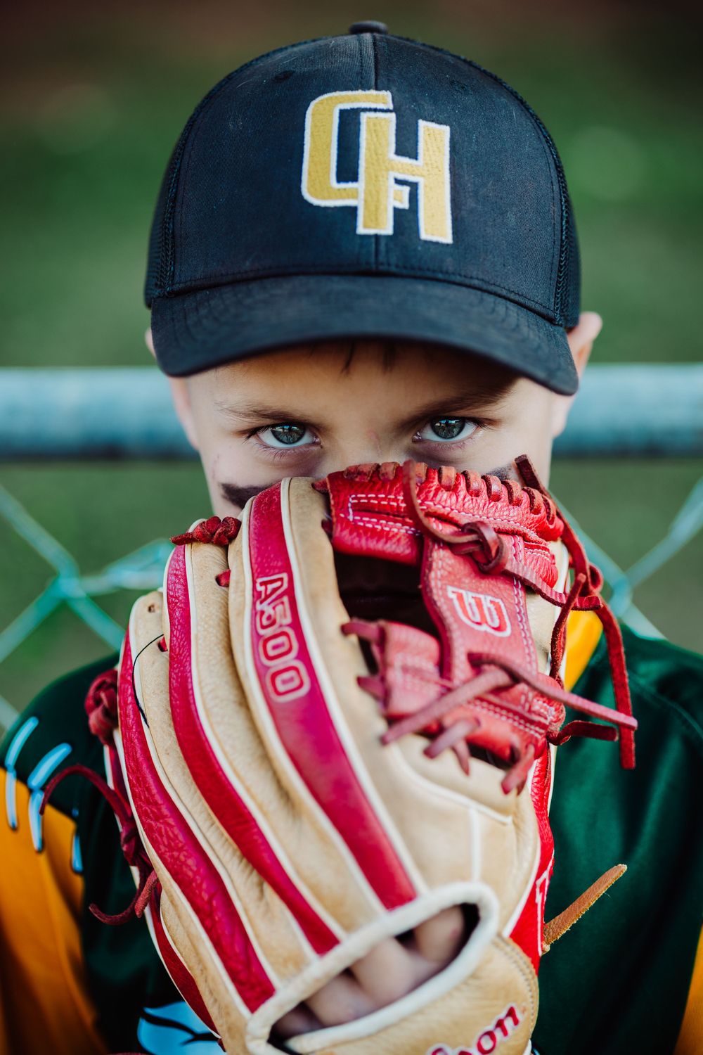 Close-up of baseball player with navy CH cap holding red and white baseball glove.