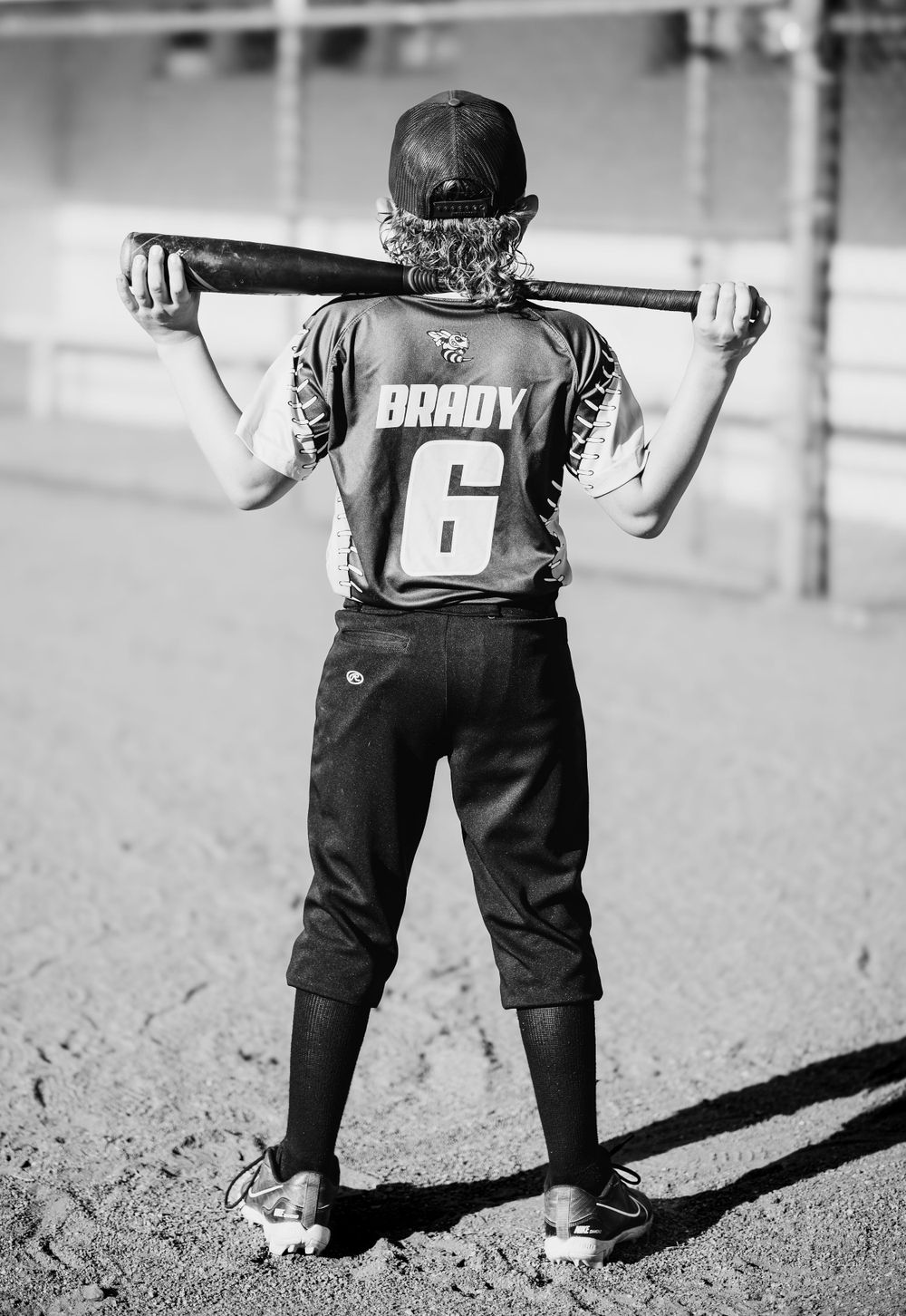 Back view of baseball player holding bat across shoulders showing jersey number 6.