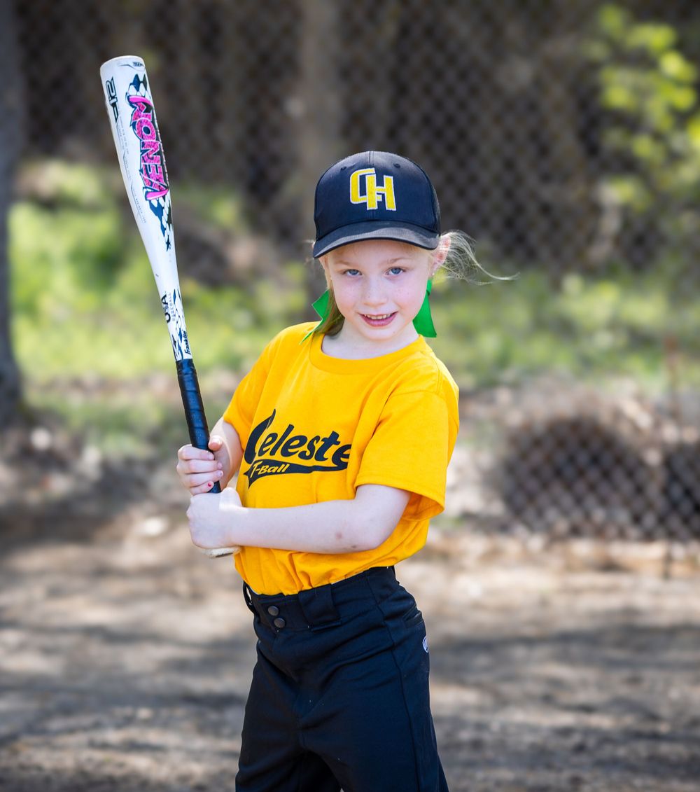 Young baseball player in yellow Celeste uniform posing with bat during practice.