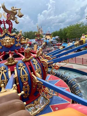 Colorful red, white and blue Dumbo-themed carnival ride with ornate details at Magic Kingdom in Disney World under cloudy skies.