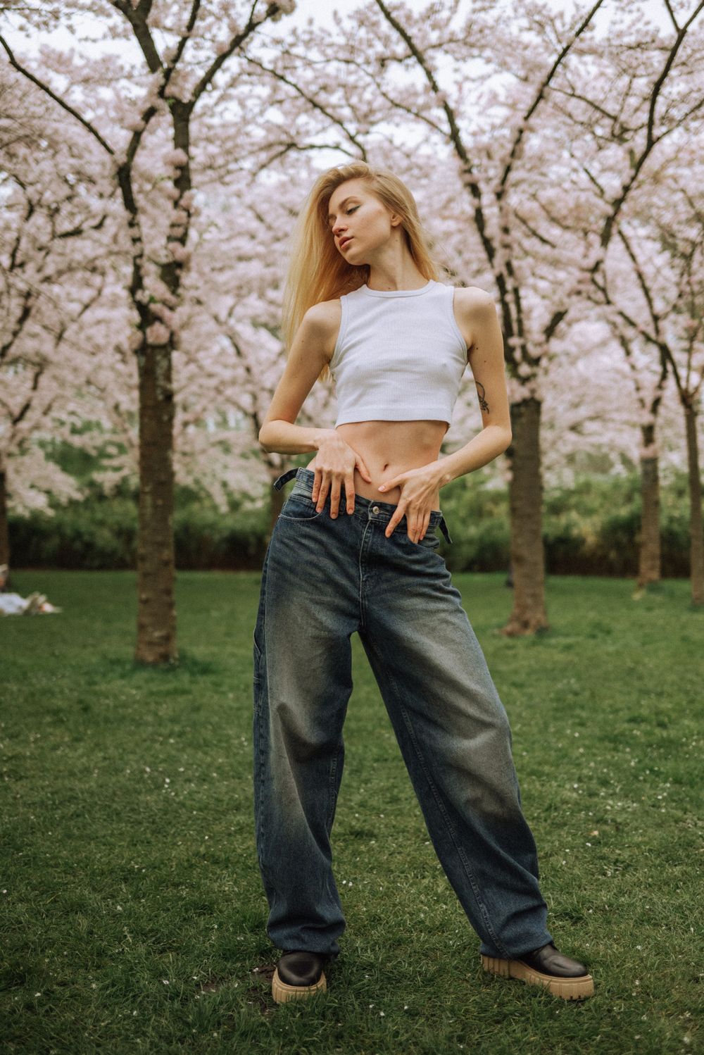 Casual denim style portrait session under blooming cherry trees.