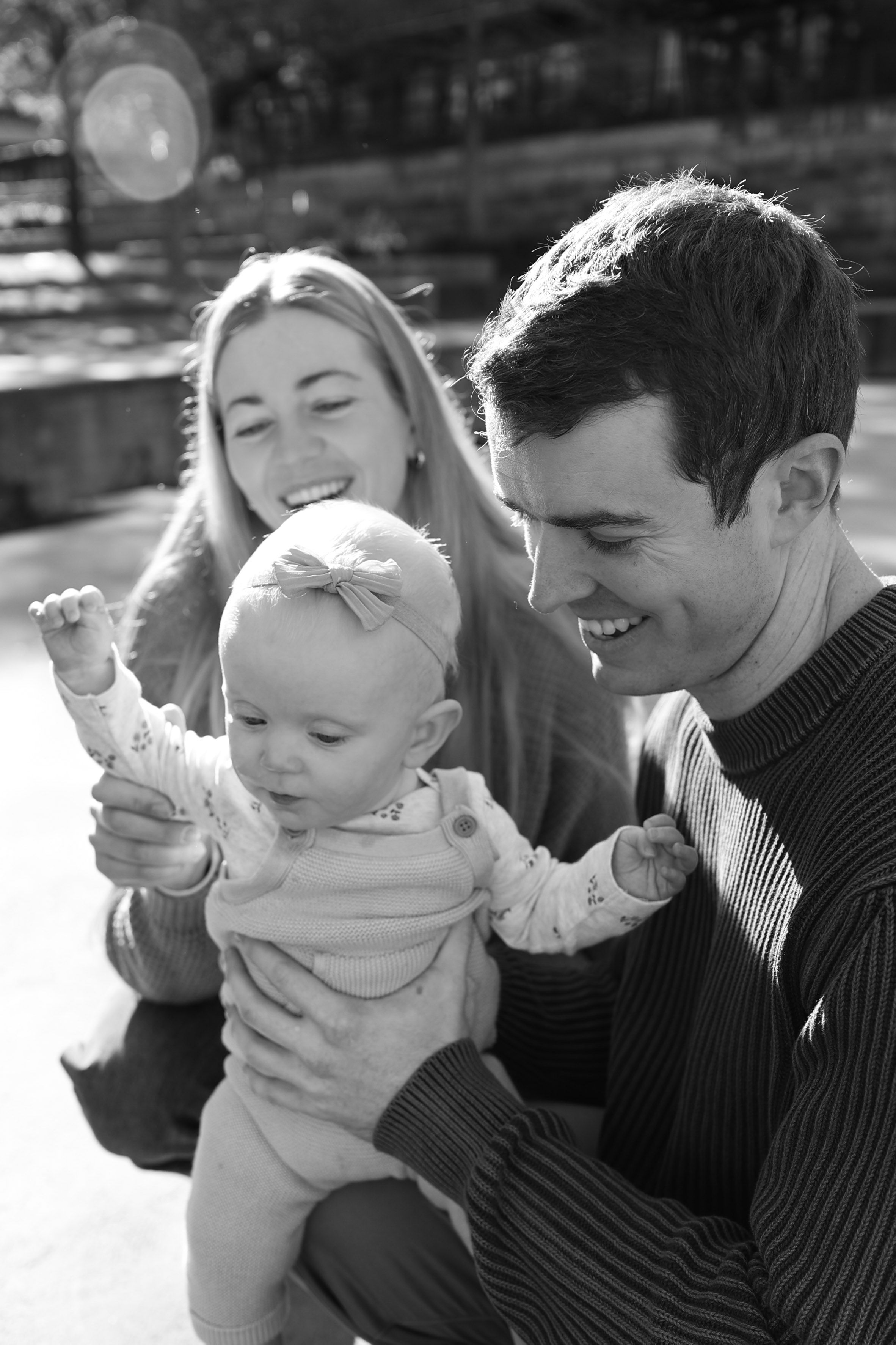 A happy family enjoying a sunny day outdoors together in black and white photography.