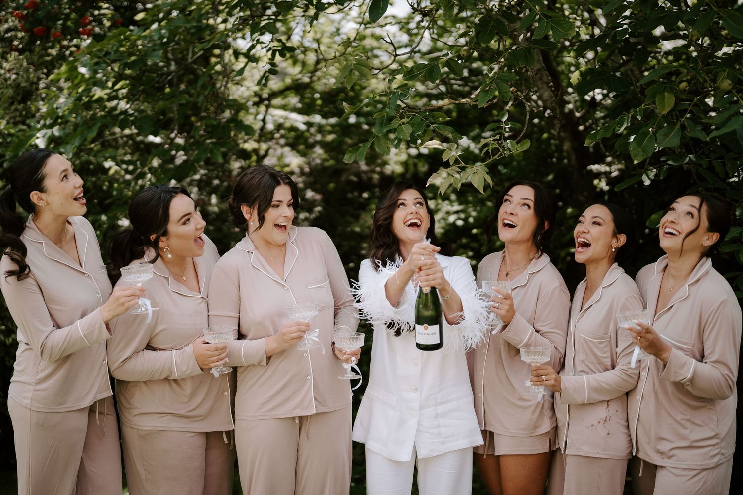 bride popping champagne with bridesmaids at the new inn cirencester