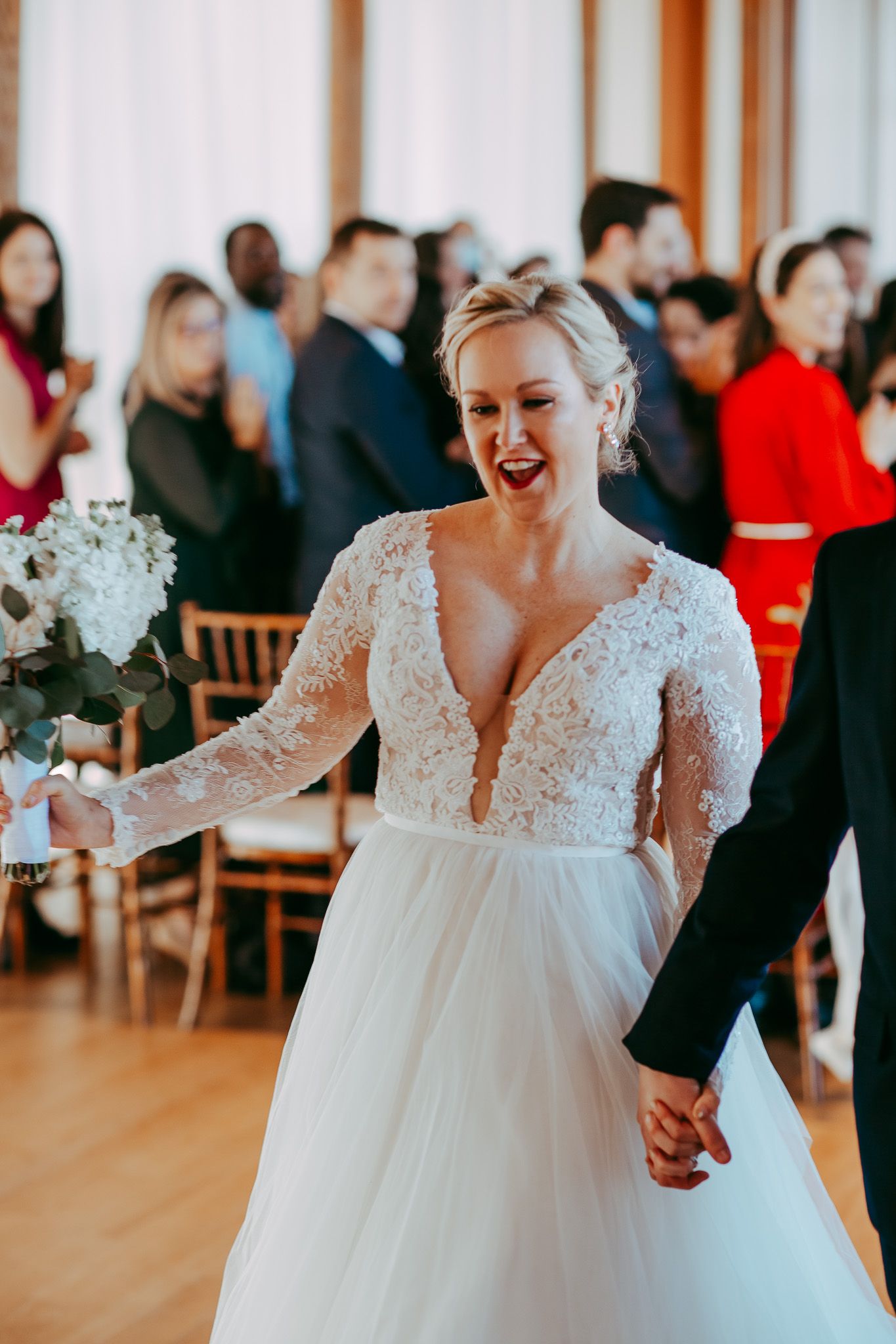 Elegant wedding celebration in bright venue with hardwood floors.