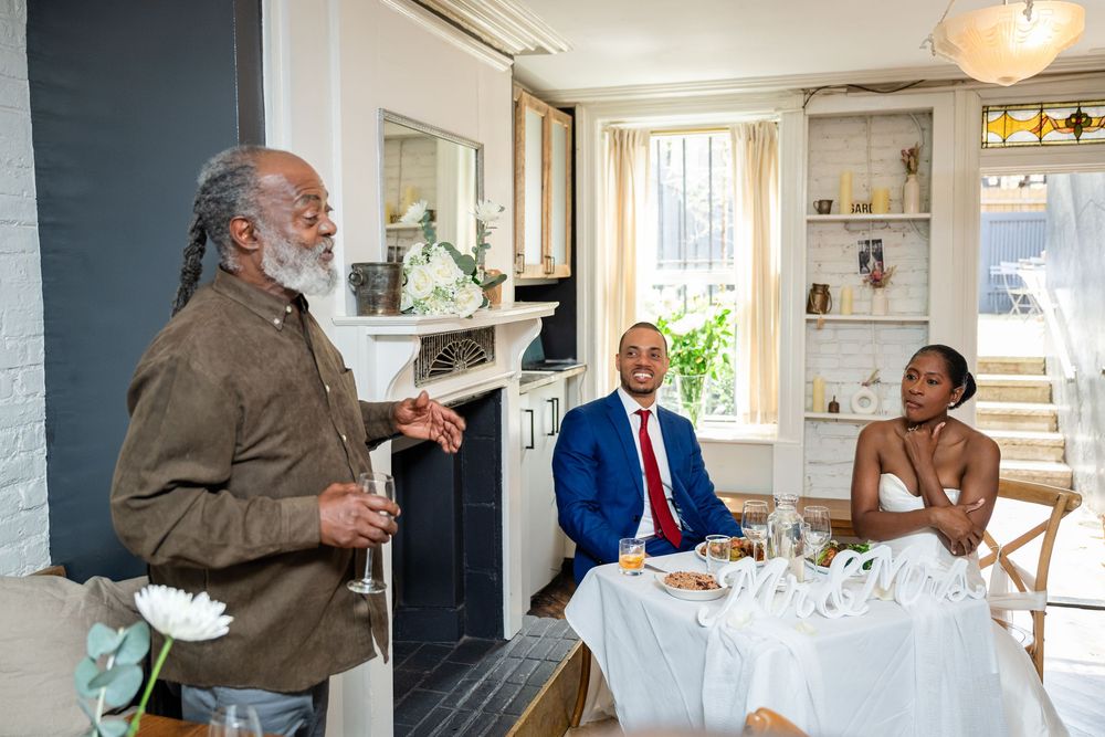 Wedding guests and couple celebrate during an intimate indoor reception.