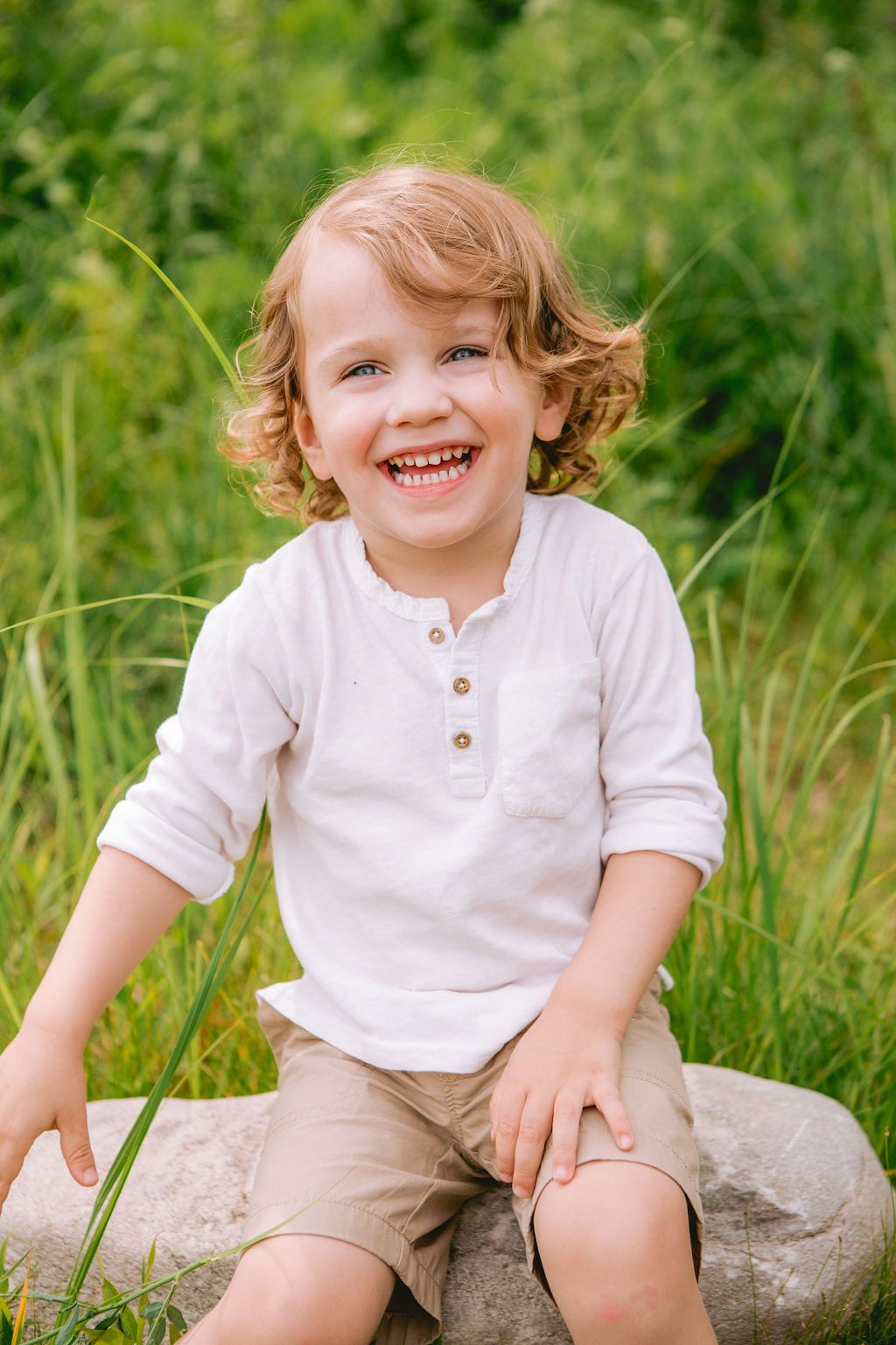 White henley shirt and khaki shorts outfit photographed outdoors on natural stone.