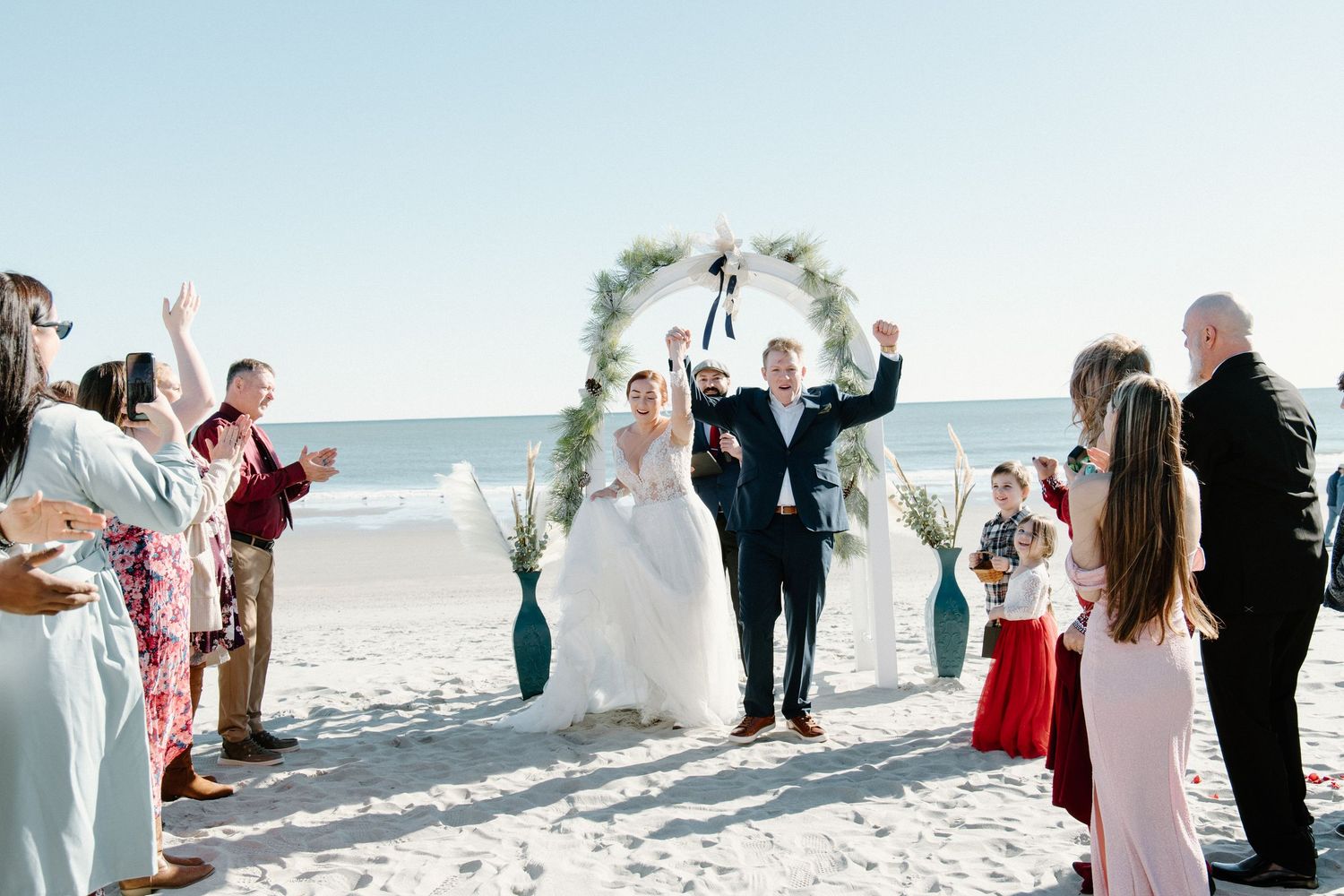 Panoramic beachfront wedding ceremony series showing guests and decor against bright blue ocean backdrop.