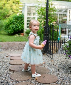 A series of stepping stone photos in a garden path with mint-colored clothing details.
