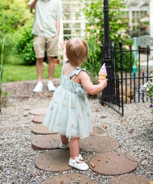 Gravel garden path with decorative stepping stones and garden elements.