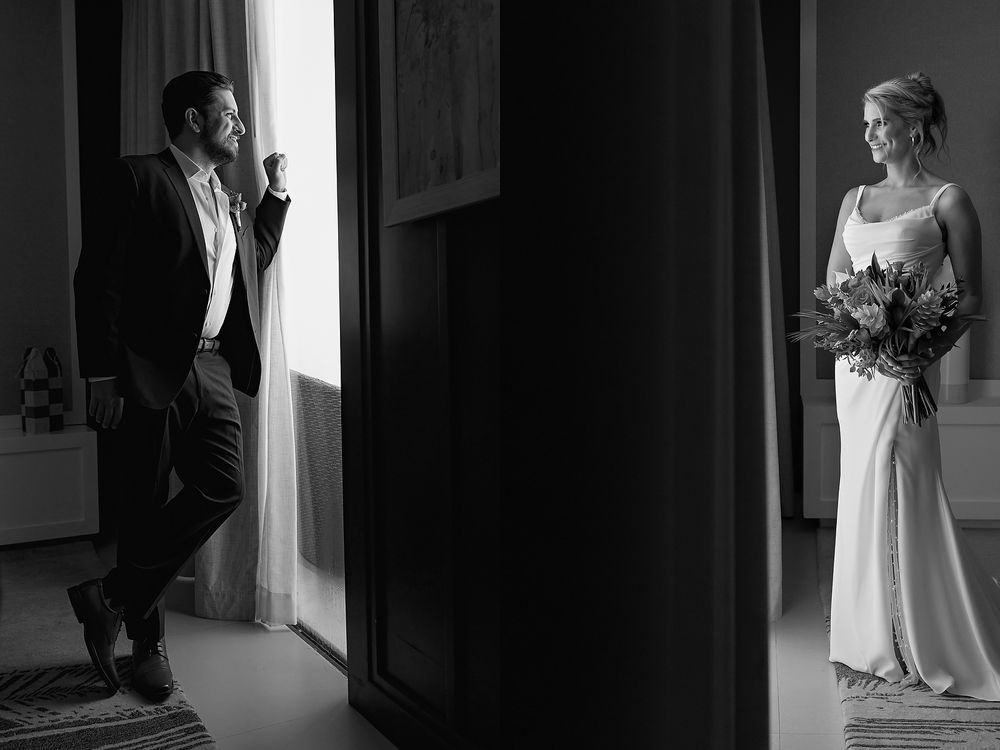 Black and white artistic wedding photo showing split composition of couple in formal attire.