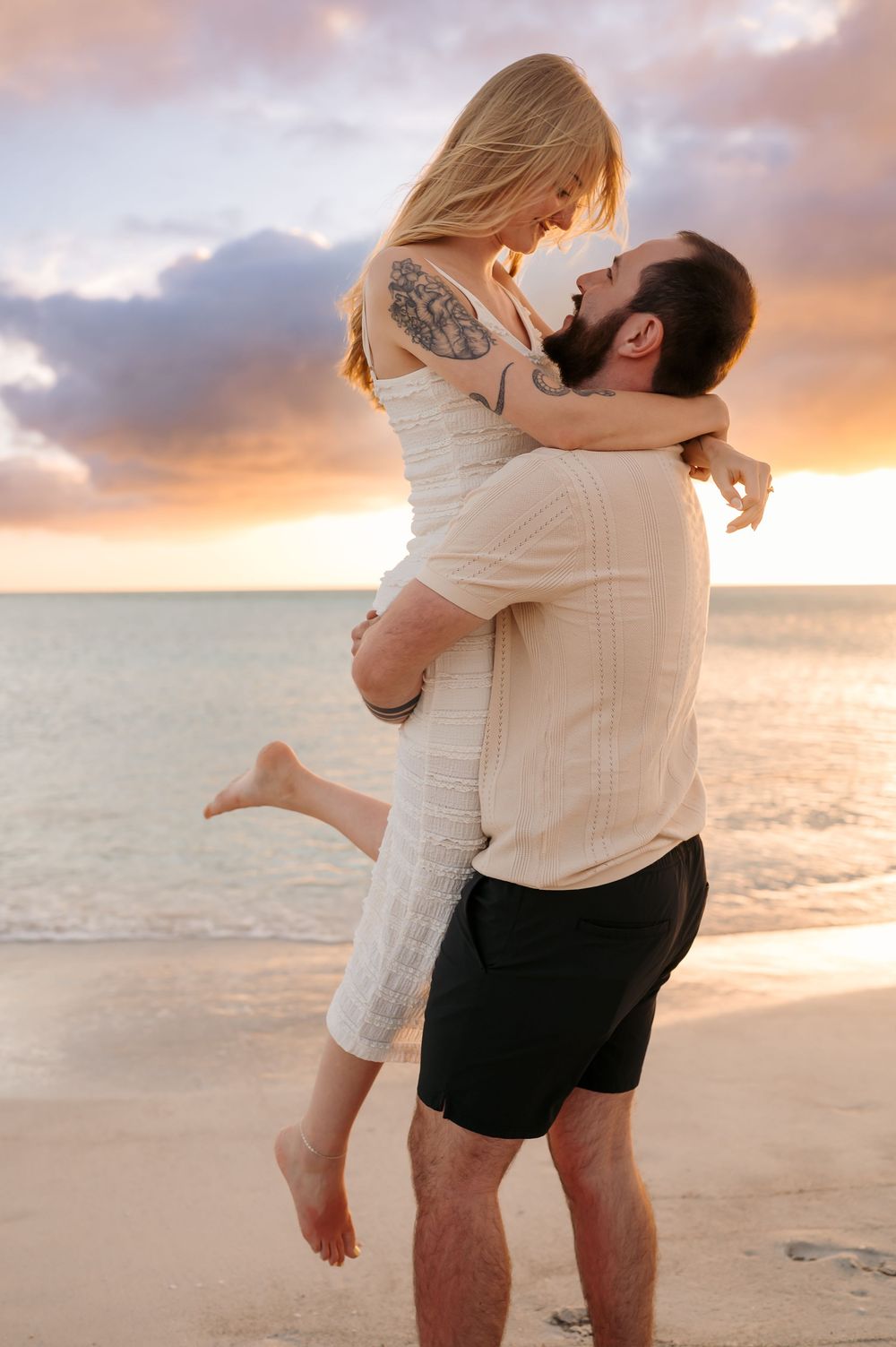 Candid engagement proposal moment during a sunset beach session