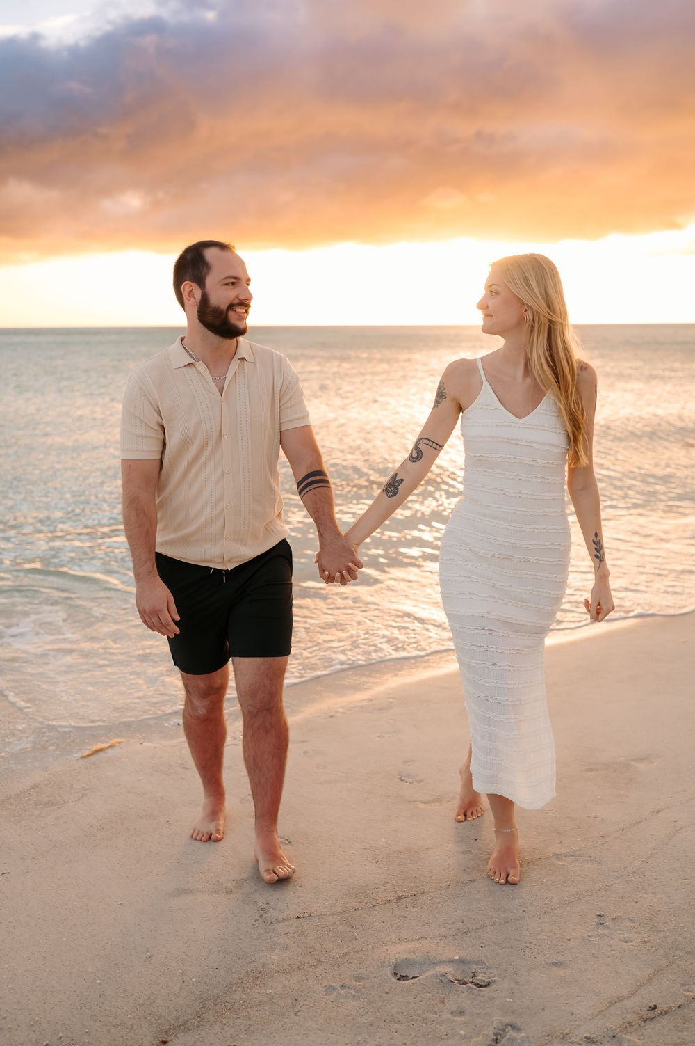 Couple laughing together during a beach engagement photoshoot