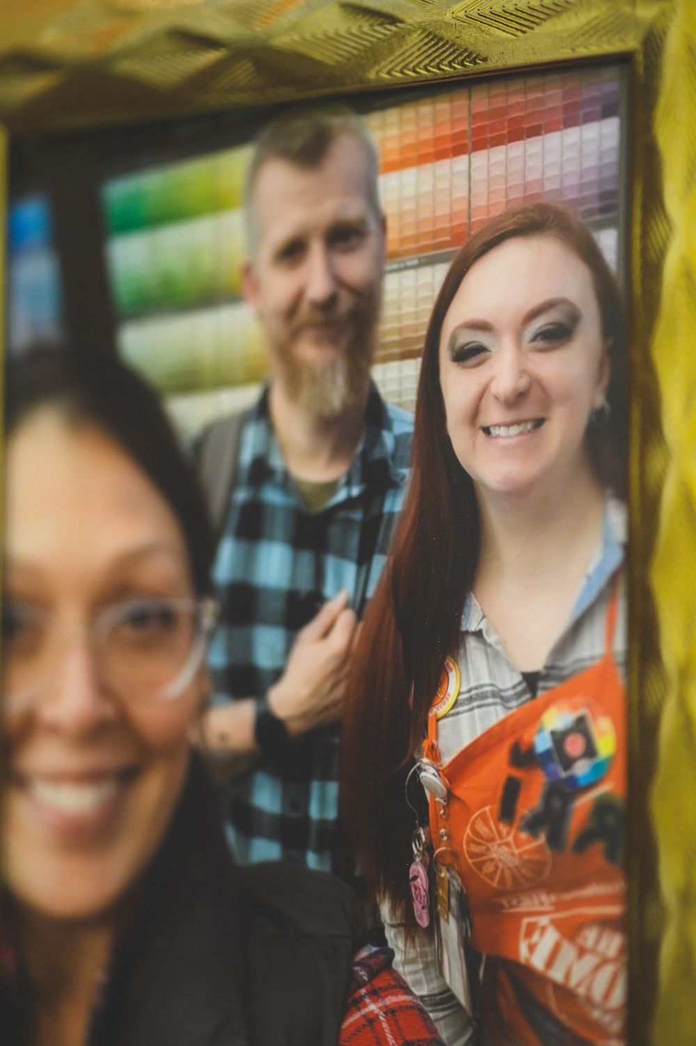 Coworkers share a candid moment together in an office setting with colorful shelving in the background.