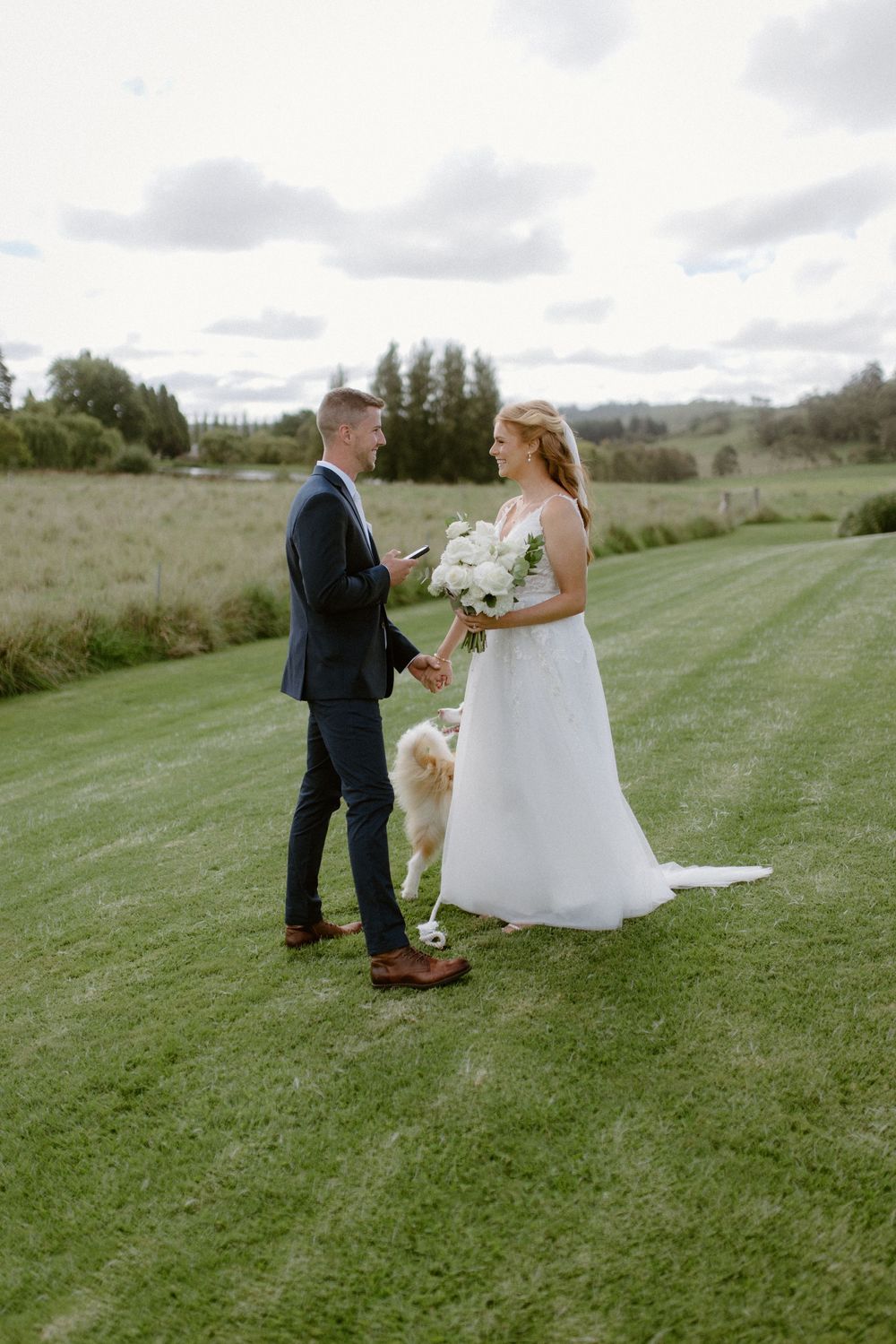 A couple shares a moment during their wedding ceremony while their dog stands faithfully beside them.