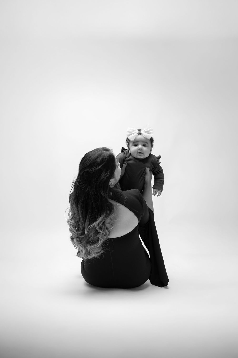 Artistic black and white photo series showing a figure in dark clothing rolling across a white background.