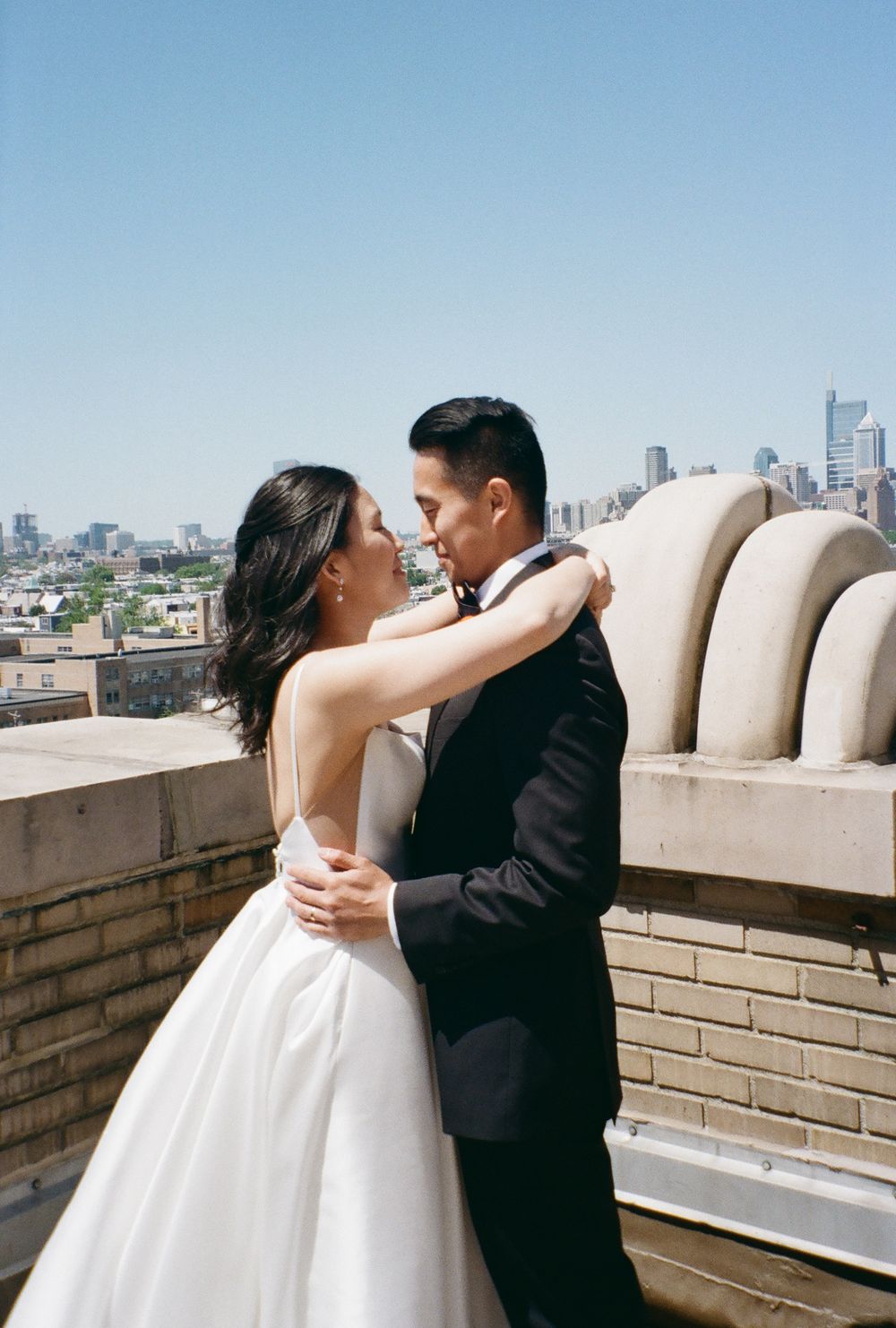 A romantic rooftop wedding portrait with city skyline backdrop.