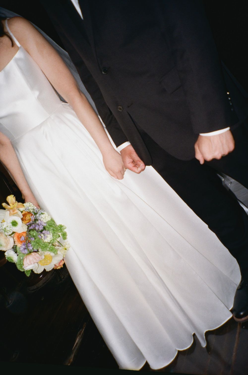 A close-up detail shot of wedding attire and floral bouquet.