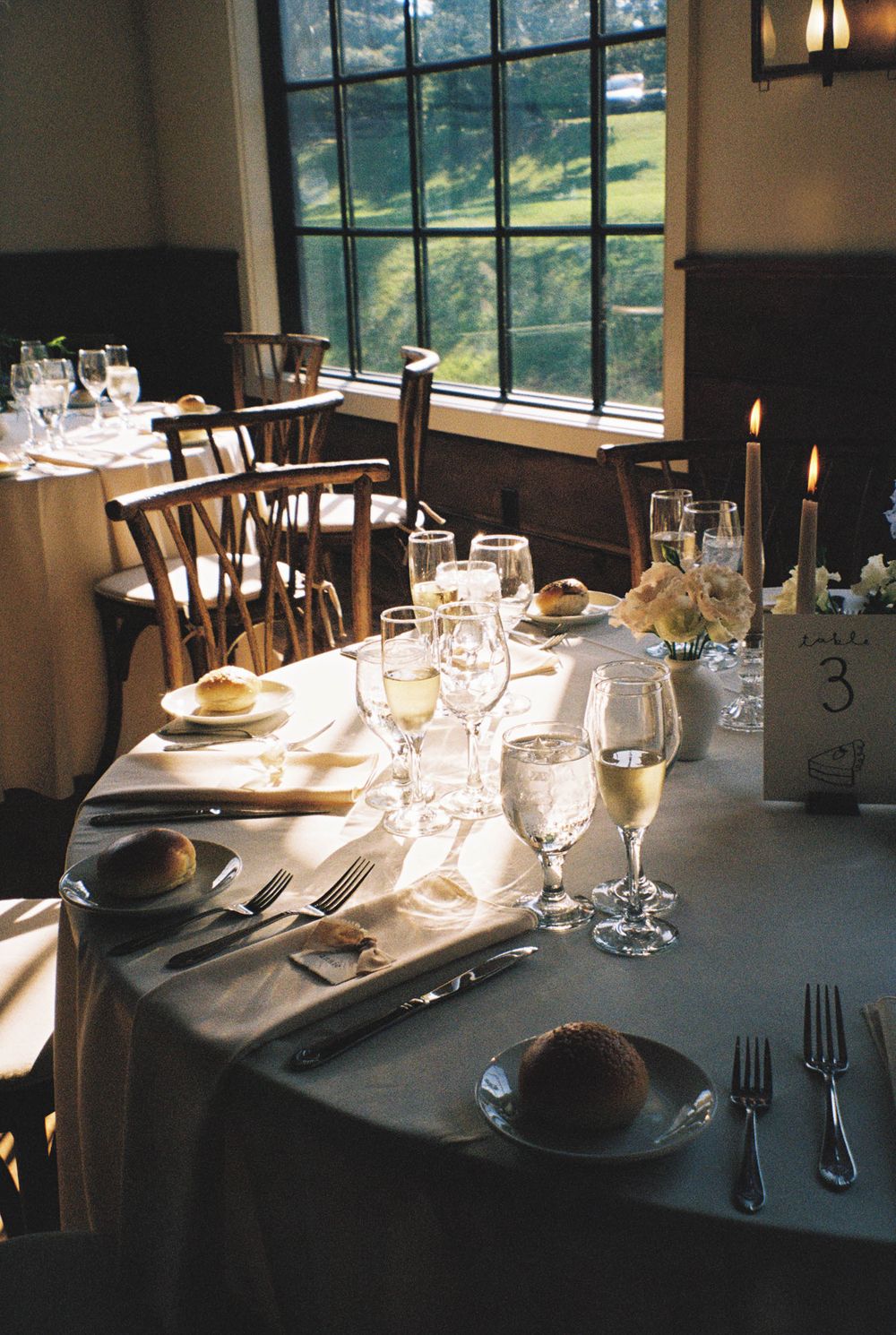 An elegant table setting at a wedding reception with wine glasses and place settings.