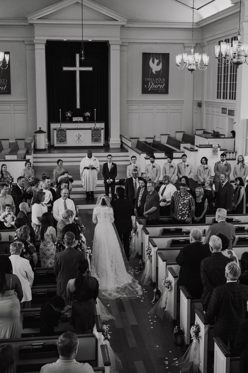 Traditional church wedding ceremony with guests seated in wooden pews.
