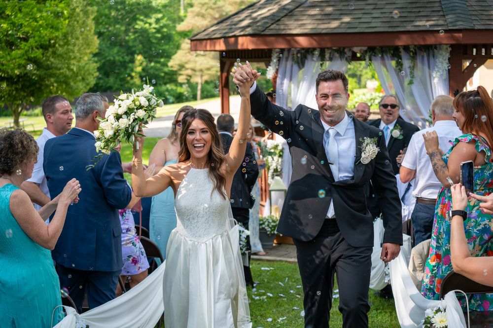Wedding ceremony celebration outdoors with guests and decorative arch.