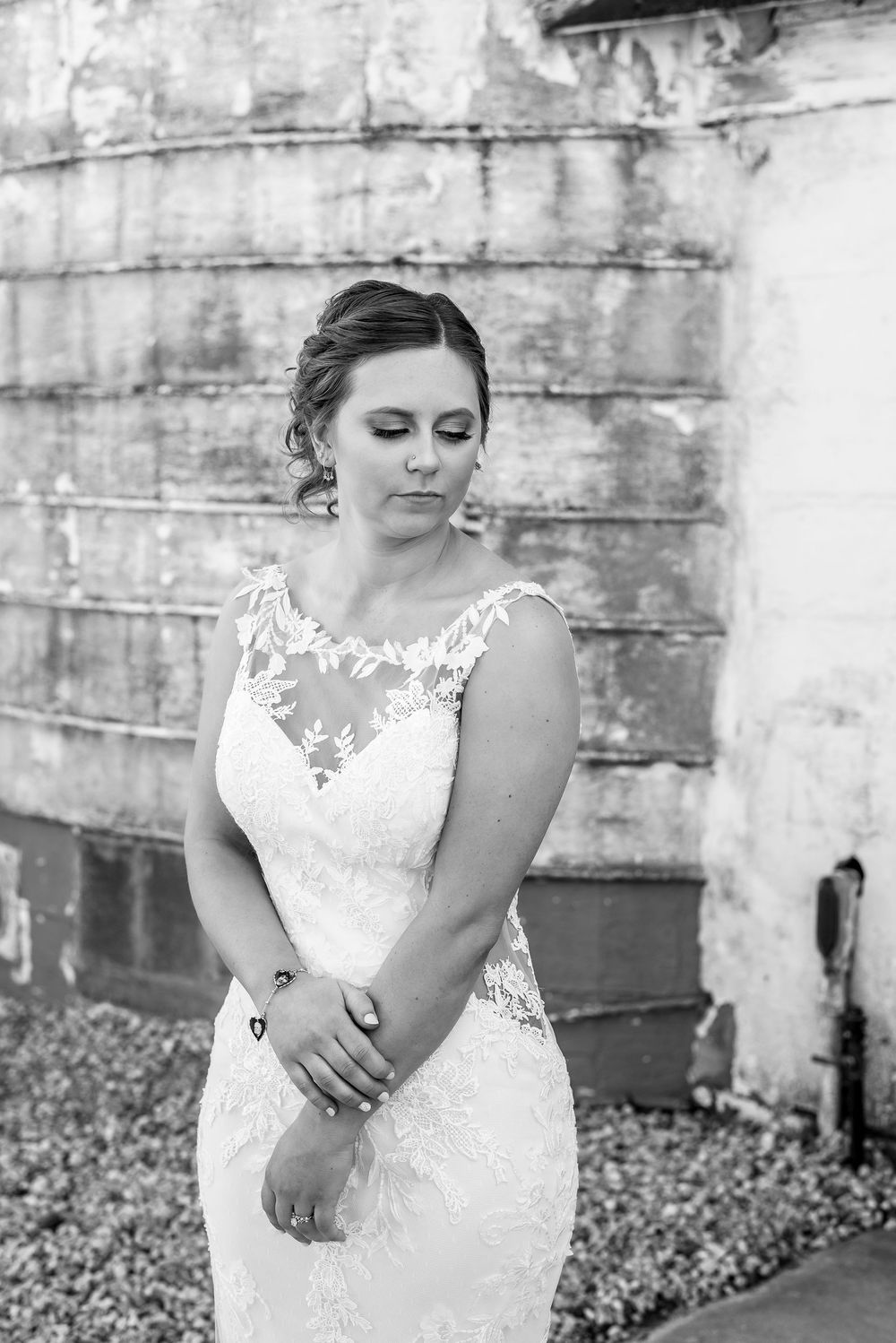 Bridal portraits against a weathered concrete wall showcasing detailed lace wedding dress.
