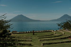 Scenic view of Lake Atitlan with twin volcanoes and terraced gardens in Guatemala.