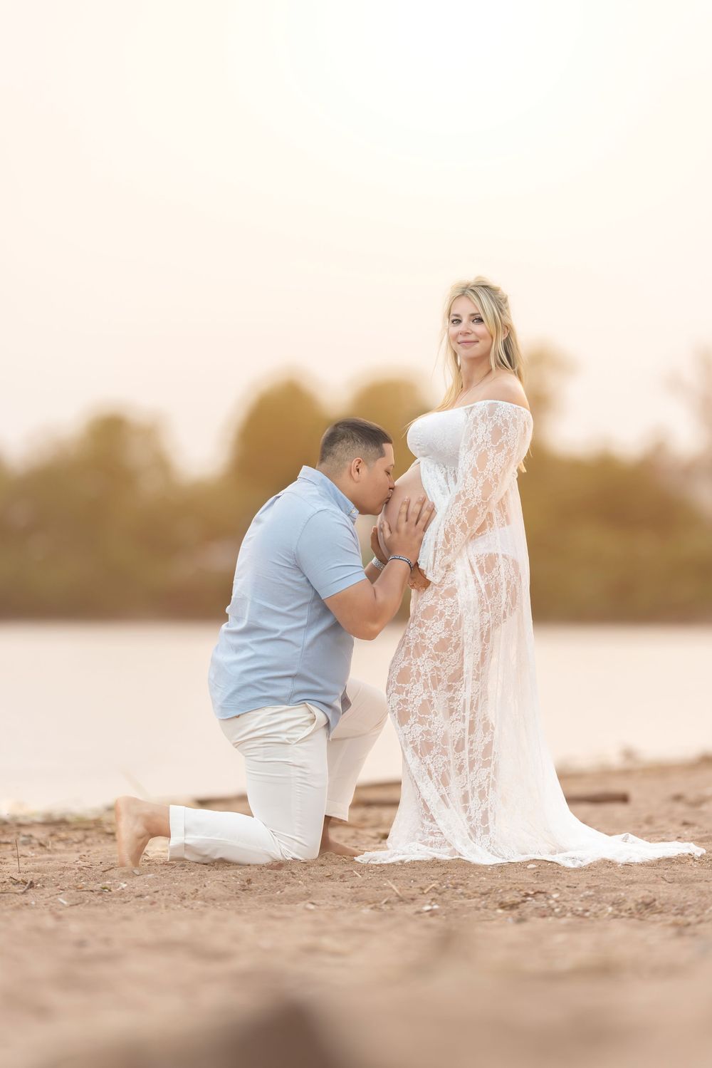 Sunset beach maternity session with couple in white lace dress.