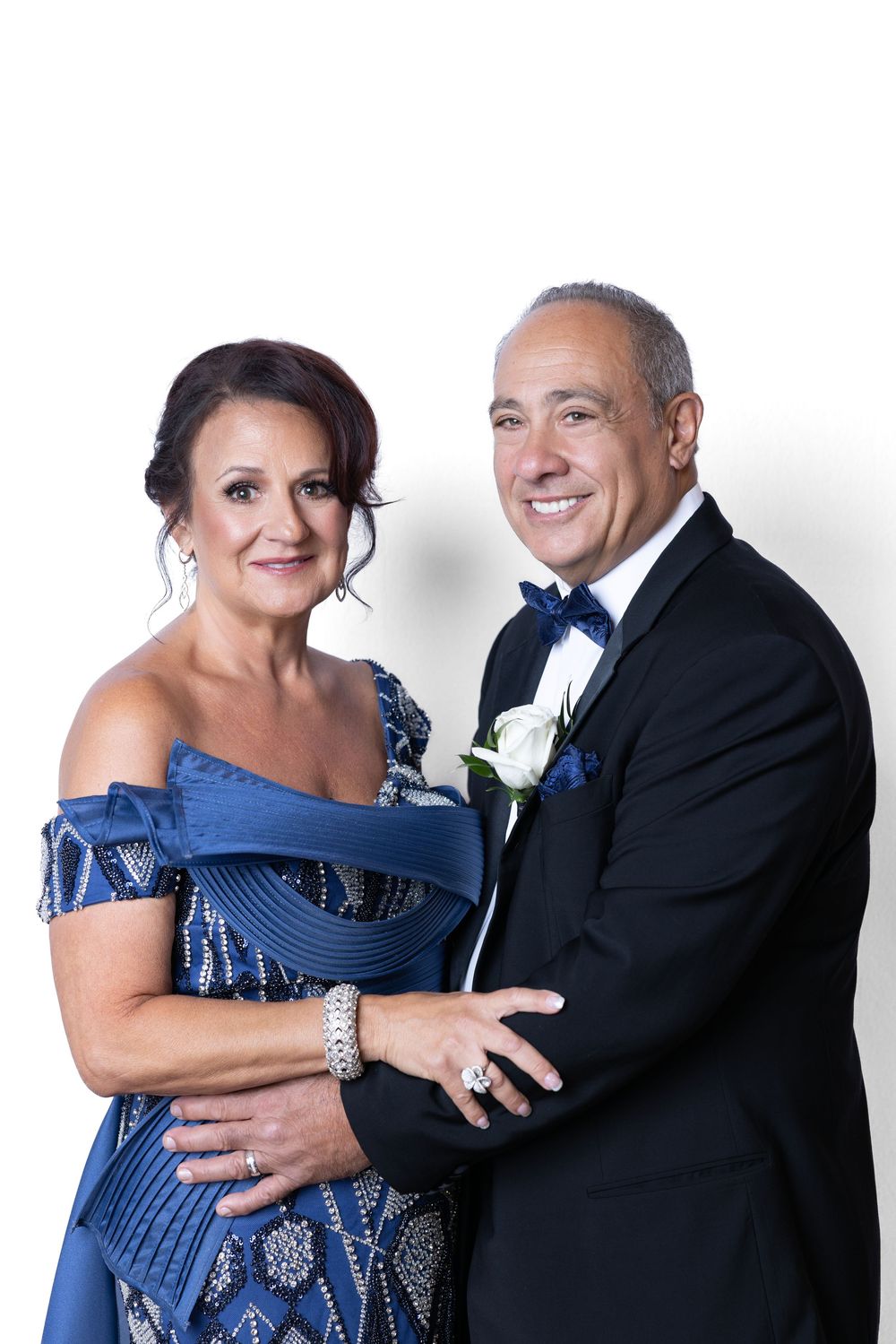 A formal portrait of a couple in evening wear, with a blue gown and black tuxedo.