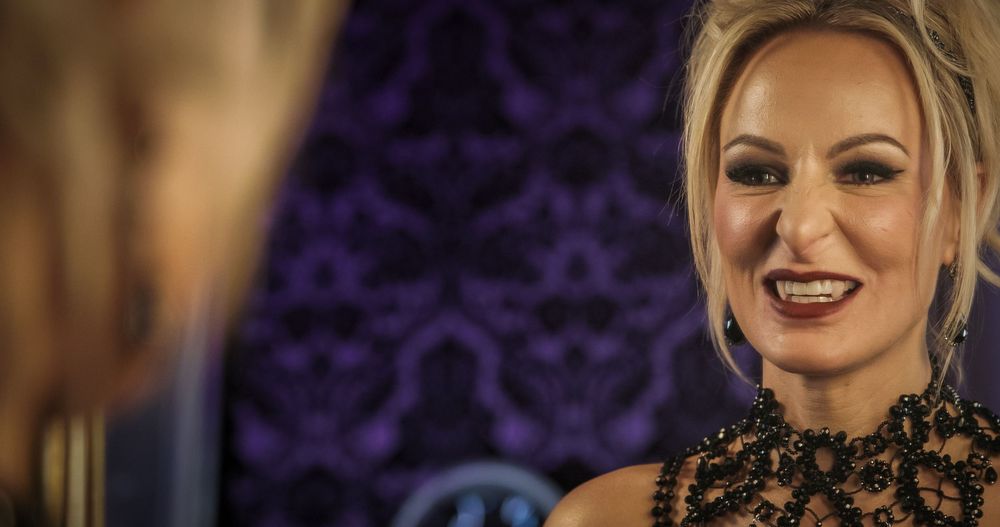 Glamorous evening makeup look with purple decor background and black beaded accessories.