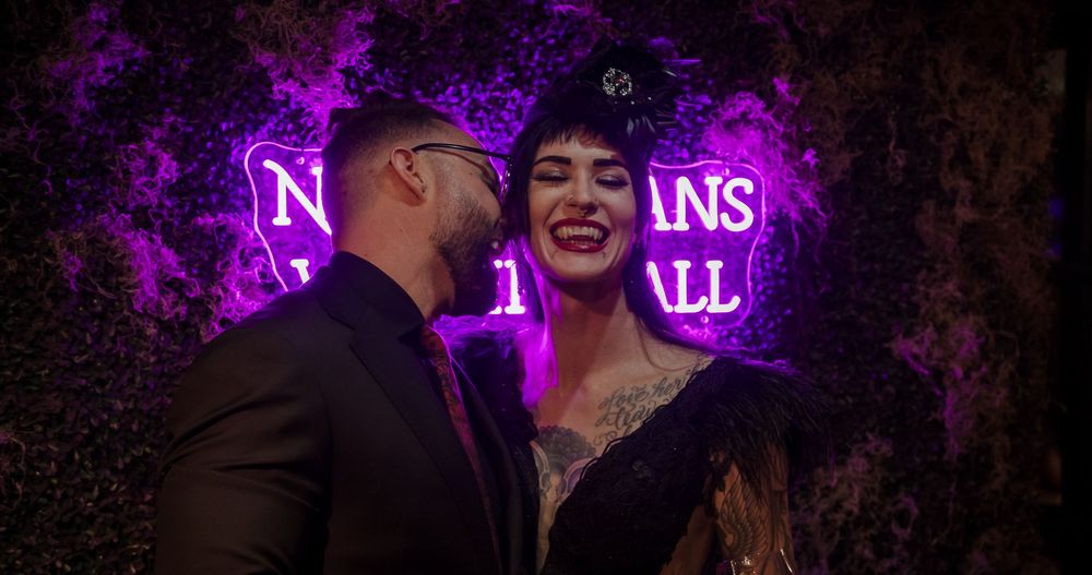 People enjoying a nightclub atmosphere with purple neon lighting and dark ambiance.