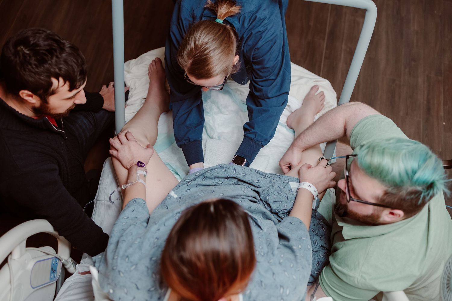 Medical professionals working together to lift and reposition a patient in a hospital bed using proper transfer techniques.