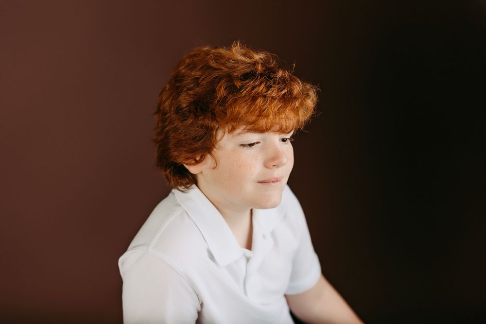 Artistic indoor portrait against dark background with natural lighting.