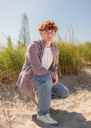Beach portrait session with sand dunes and beach grass in the background.