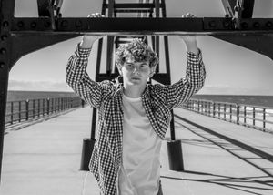 Black and white sequence of someone posing under a wooden pier structure.