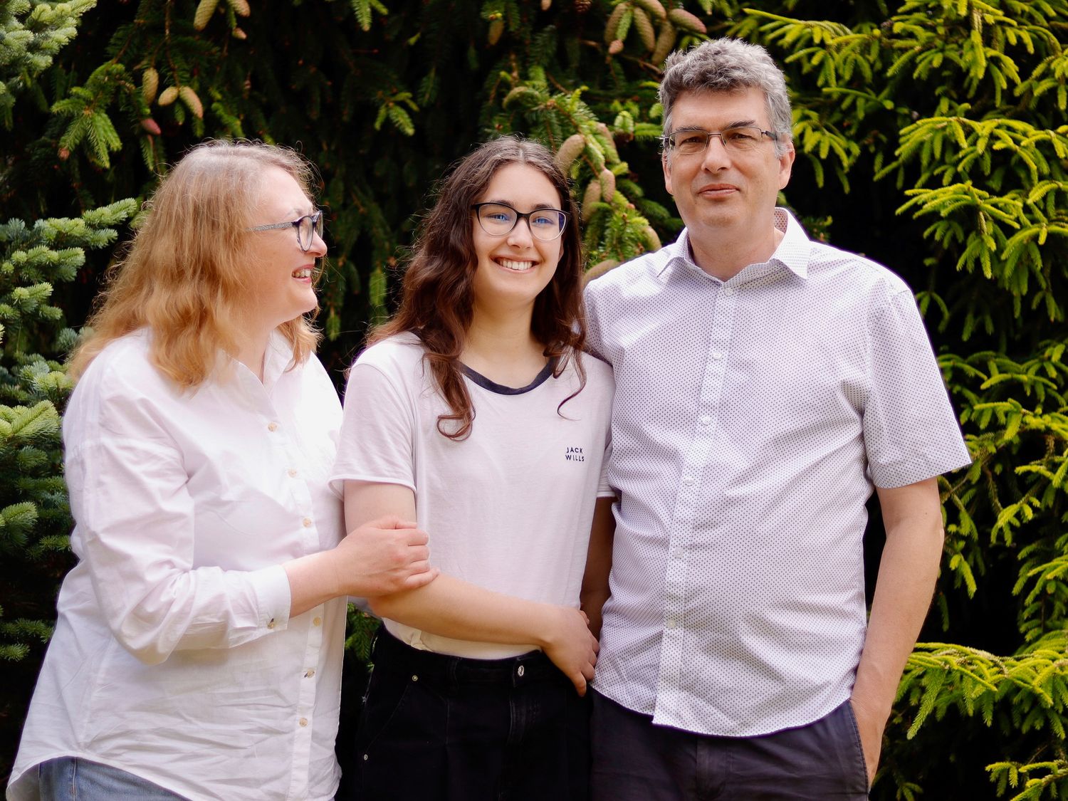 The family of three gathered together in their garden in Surrey for Family Photo Shoot. No posing, only lifestyle photography for Family.