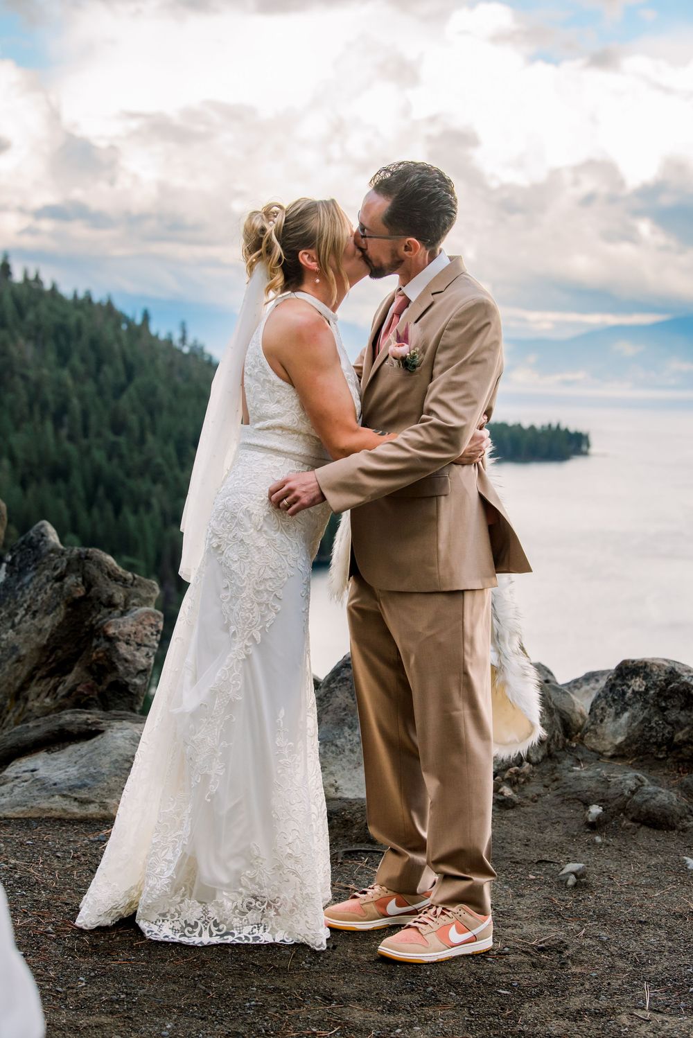 A couple shares their first dance on a rocky mountain overlook with evergreen trees in the background. A Destination Wedding at Emerald Bay
