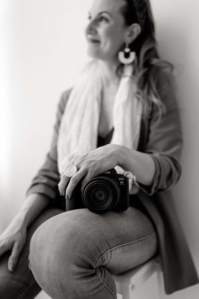 A black and white photo series showing a person in casual clothing sitting against a wall in different relaxed poses.
