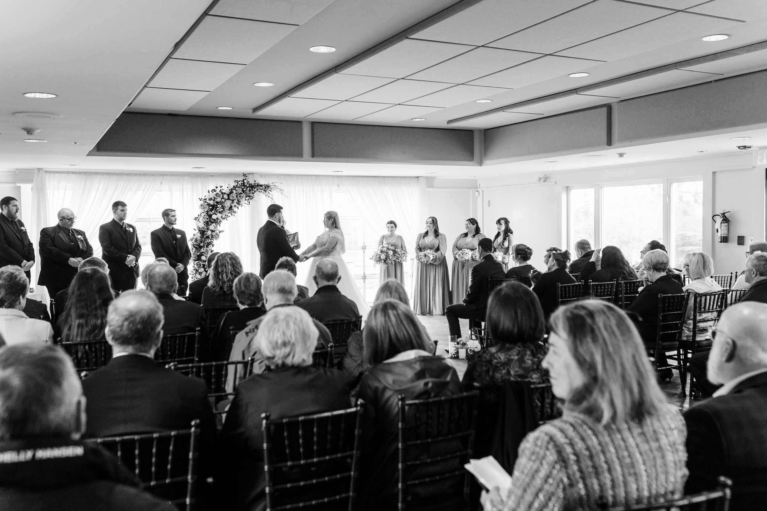 A group of people stand together in an office space during what appears to be a business meeting or presentation.