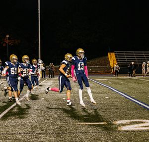 Team members stretch in formation on the football field during evening practice.