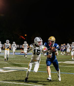 Football players engage in active gameplay during a nighttime match.